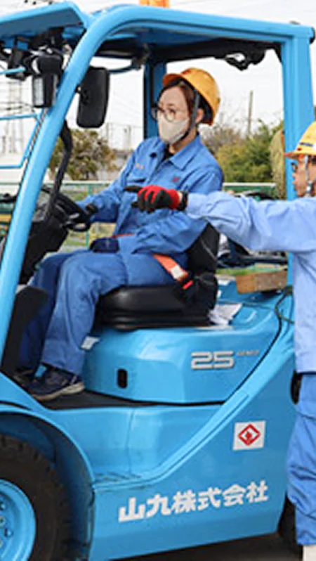 フォークリフトを操縦する女性と指導員